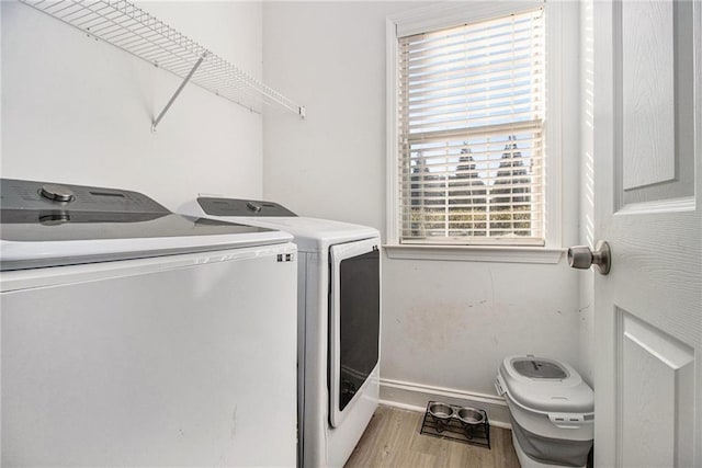 laundry room featuring laundry area, light wood-style floors, baseboards, and washing machine and clothes dryer