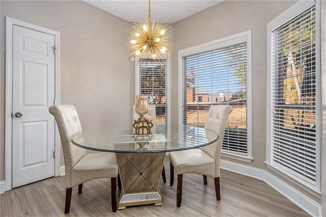 dining room with a chandelier, baseboards, and wood finished floors