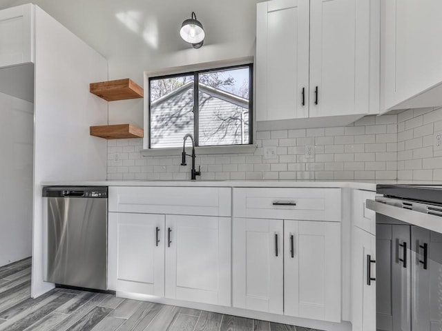 kitchen featuring stainless steel dishwasher, tasteful backsplash, white cabinetry, and light hardwood / wood-style flooring