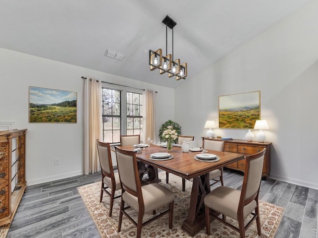 dining area with lofted ceiling and an inviting chandelier