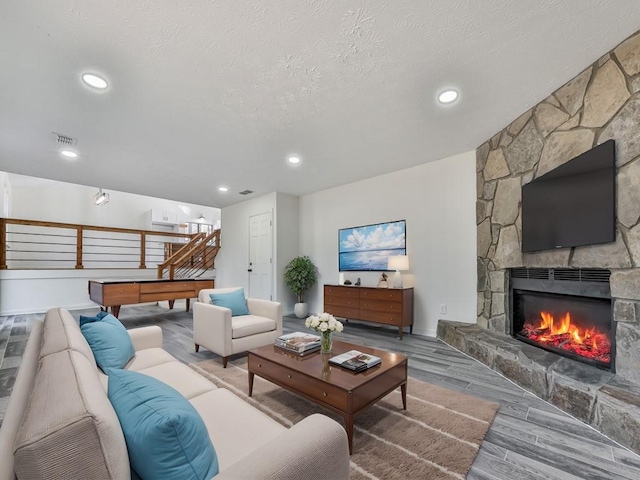 living room with a fireplace and a textured ceiling