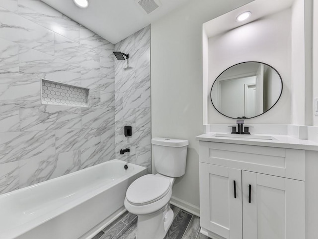 full bathroom with vanity, tiled shower / bath combo, and toilet