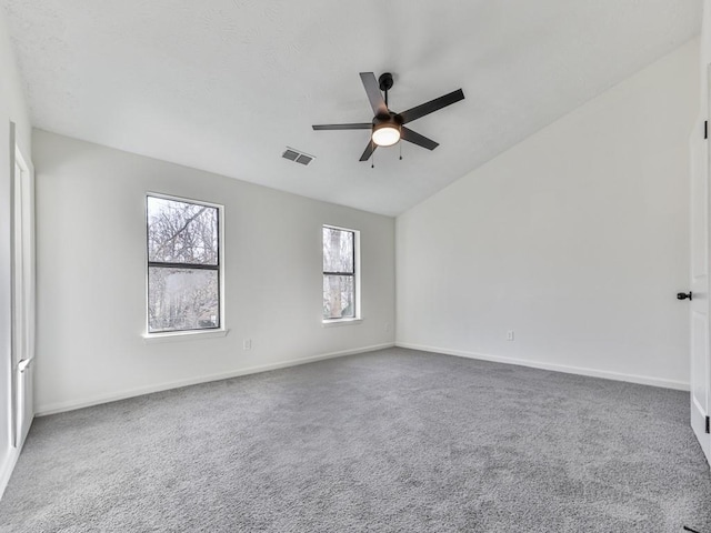 empty room featuring ceiling fan, carpet floors, and lofted ceiling