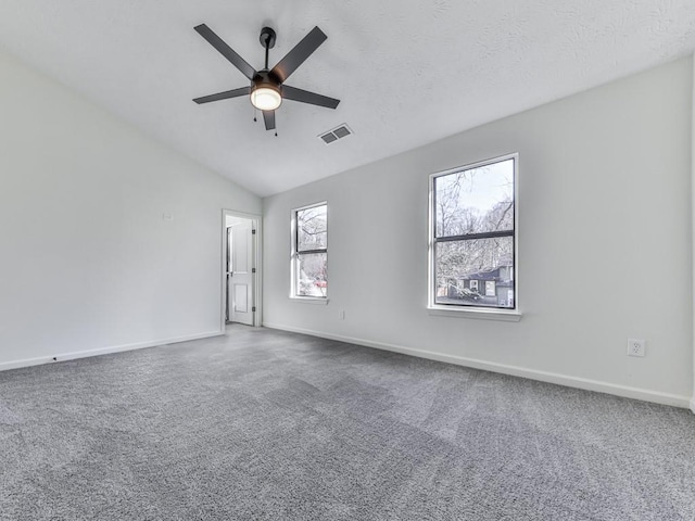 carpeted spare room featuring ceiling fan and lofted ceiling