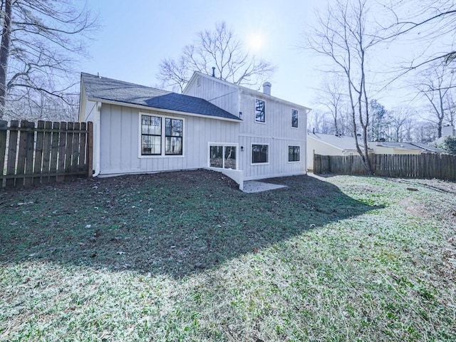 rear view of property featuring a lawn