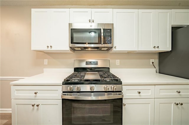 kitchen with white cabinets, stainless steel appliances, and light countertops