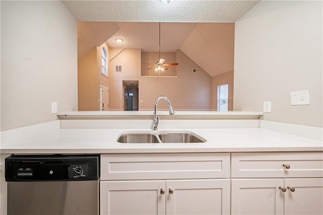 kitchen featuring light countertops, stainless steel dishwasher, a sink, and white cabinetry