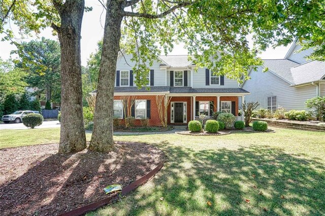 view of front of house with covered porch and a front yard