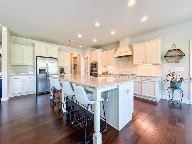 724 Laura Jean Ct, Buford, GA 30518 - kitchen with appliances with stainless steel finishes, premium range hood, dark wood-type flooring, a kitchen breakfast bar, and tasteful backsplash