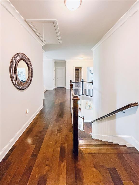 724 Laura Jean Ct, Buford, GA 30518 - hall featuring attic access, hardwood / wood-style floors, baseboards, an upstairs landing, and crown molding