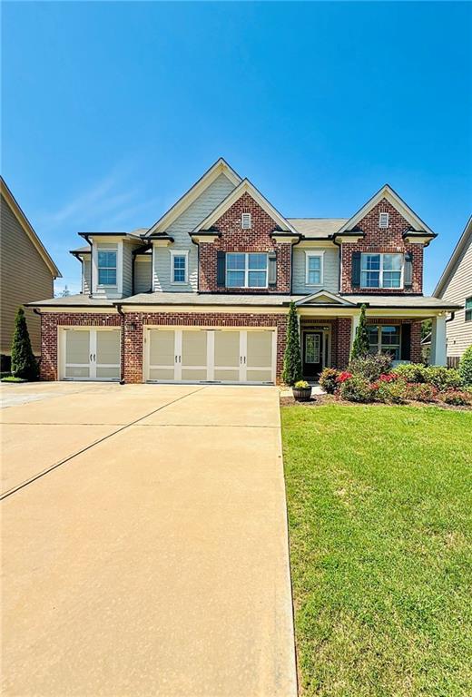 724 Laura Jean Ct, Buford, GA 30518 - view of front facade featuring brick siding, a garage, driveway, and a front lawn