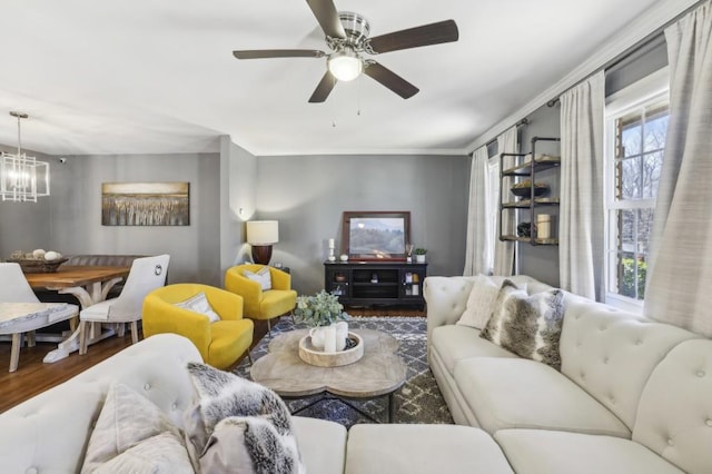 living room with ceiling fan with notable chandelier and wood finished floors