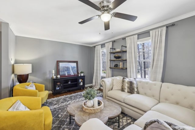 living room featuring baseboards, wood finished floors, a ceiling fan, and crown molding