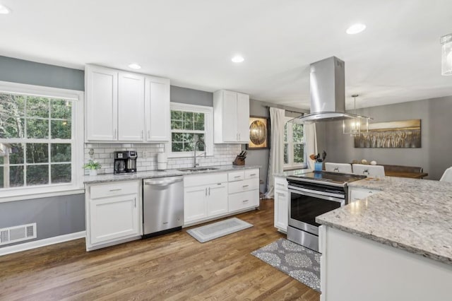 kitchen featuring a sink, visible vents, white cabinets, appliances with stainless steel finishes, and island exhaust hood