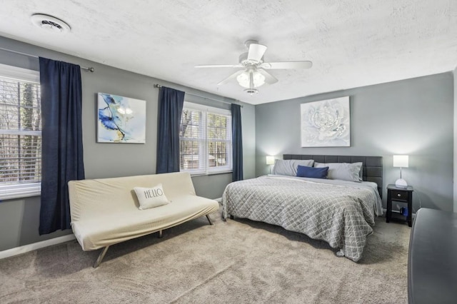 carpeted bedroom featuring visible vents, ceiling fan, a textured ceiling, and baseboards