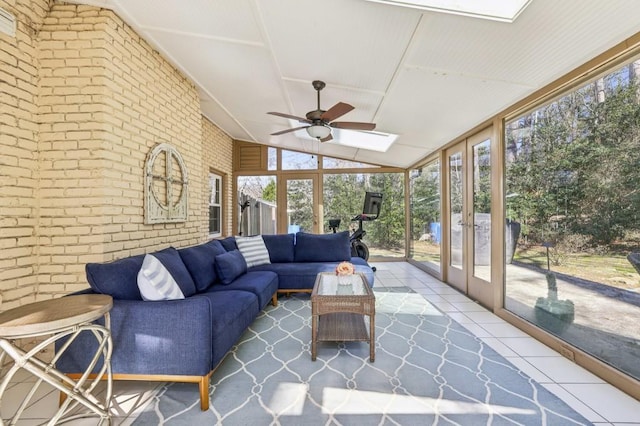 sunroom featuring vaulted ceiling with skylight, a wealth of natural light, and a ceiling fan