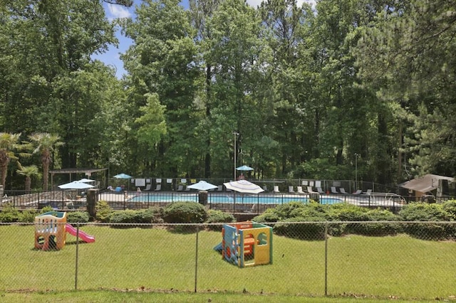 view of jungle gym with a yard, fence, and a community pool