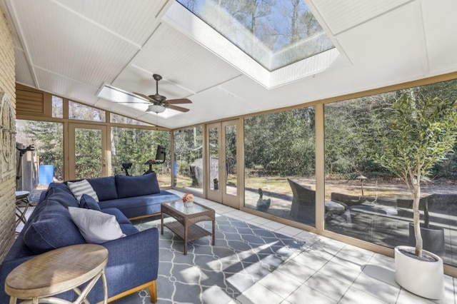 sunroom / solarium featuring vaulted ceiling with skylight, a healthy amount of sunlight, and ceiling fan