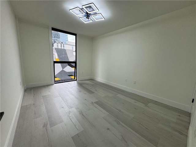 empty room with expansive windows and light wood-type flooring