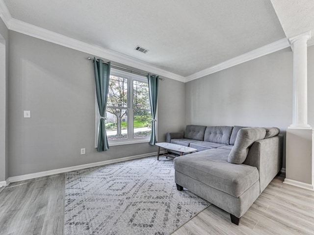 living room featuring light hardwood / wood-style floors, ornate columns, and ornamental molding