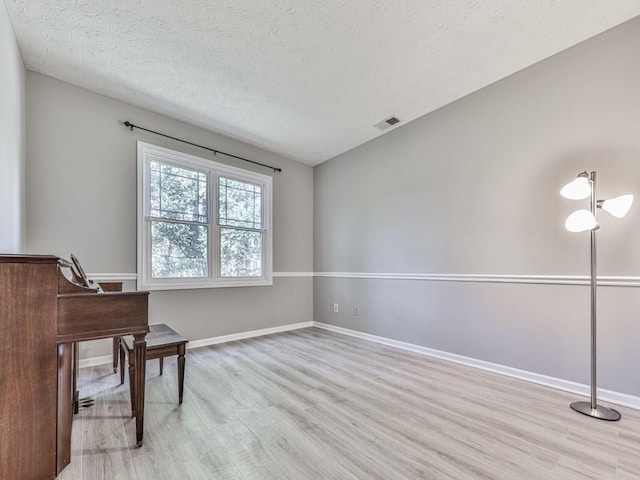 office space featuring light hardwood / wood-style floors and a textured ceiling