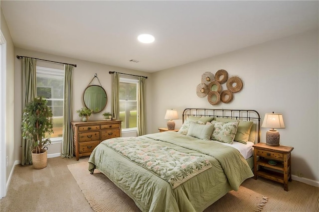 bedroom featuring light colored carpet, multiple windows, and baseboards