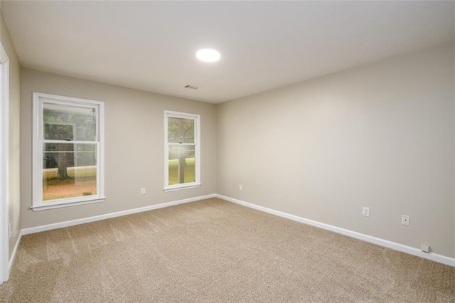 empty room featuring carpet and baseboards