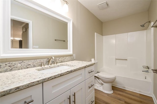 bathroom featuring wood finished floors, vanity, toilet, and  shower combination