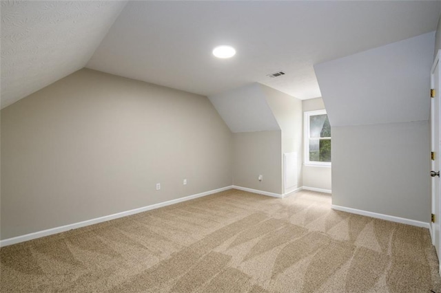 bonus room featuring baseboards, light carpet, and vaulted ceiling