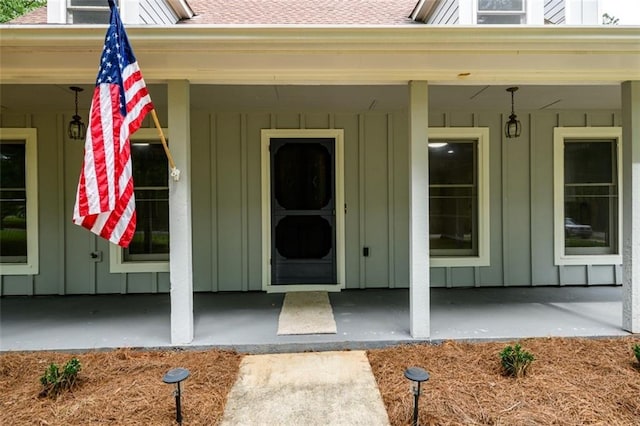 entrance to property with board and batten siding and a porch