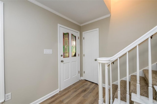 entrance foyer with wood finished floors, ornamental molding, stairway, and baseboards
