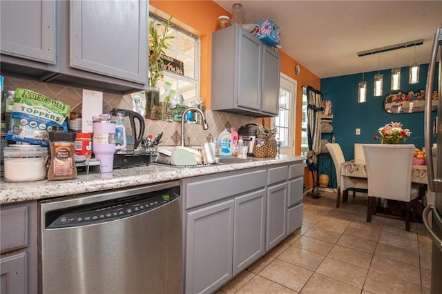 kitchen featuring decorative backsplash, dishwasher, gray cabinetry, a sink, and light tile patterned flooring