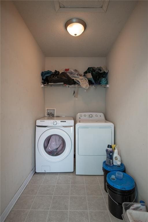 clothes washing area featuring laundry area, light tile patterned floors, and separate washer and dryer