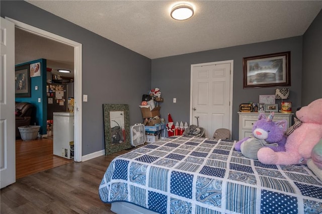 bedroom featuring a textured ceiling, wood finished floors, and baseboards