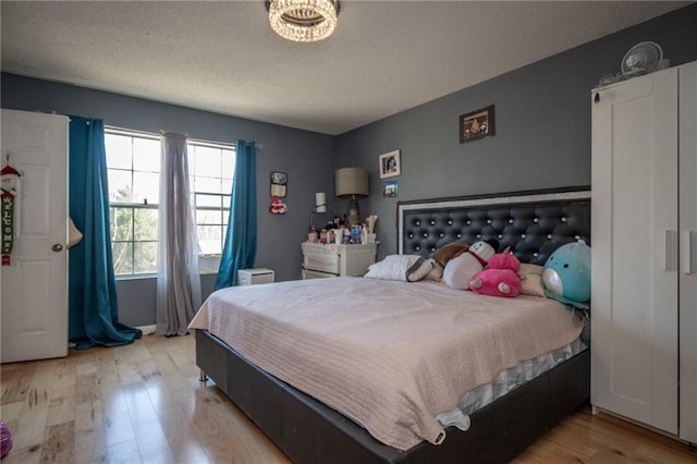 bedroom with a textured ceiling and light wood-type flooring