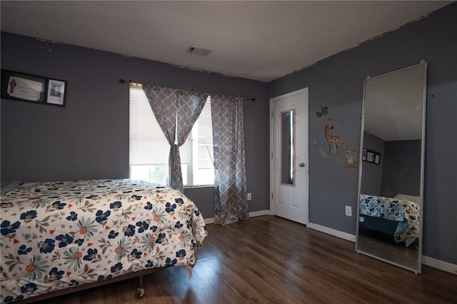 bedroom featuring wood finished floors, visible vents, and baseboards