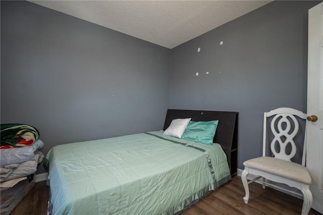 bedroom with a textured ceiling and wood finished floors