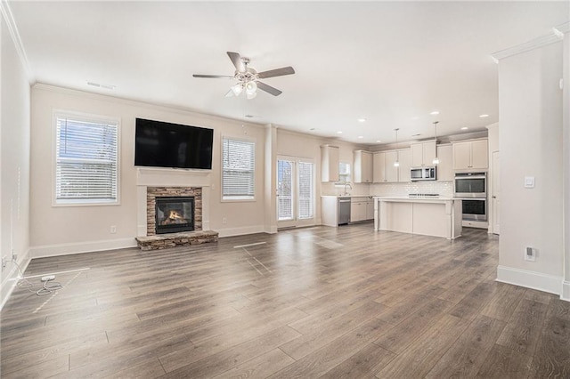 unfurnished living room with crown molding, a healthy amount of sunlight, and hardwood / wood-style flooring