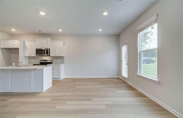 kitchen with white cabinets, a healthy amount of sunlight, and appliances with stainless steel finishes