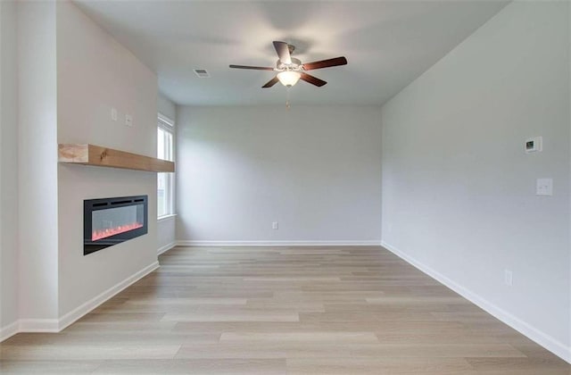 unfurnished living room with light wood-type flooring and ceiling fan