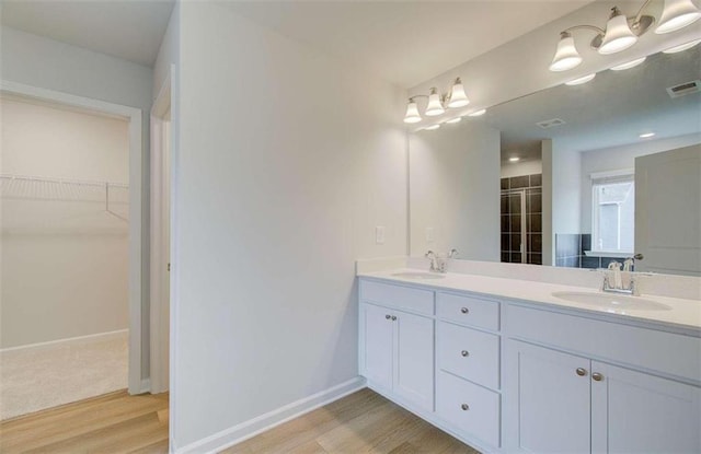 bathroom with a shower with door, hardwood / wood-style floors, and vanity