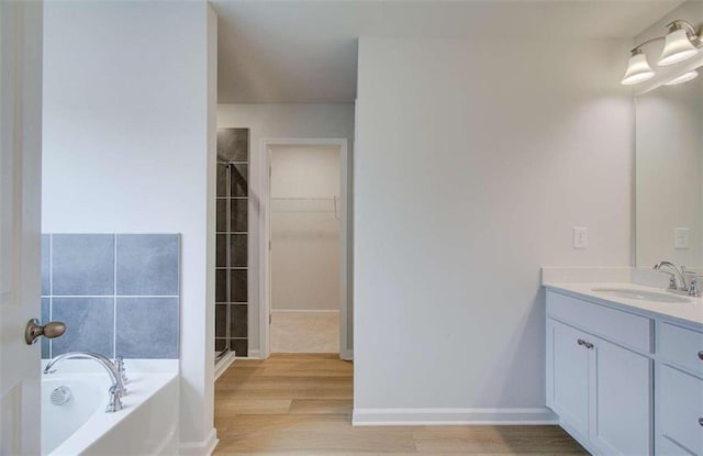 bathroom with independent shower and bath, hardwood / wood-style floors, and vanity