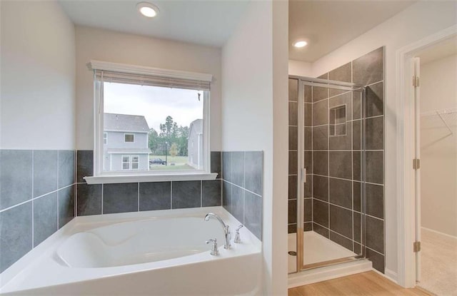 bathroom with shower with separate bathtub and hardwood / wood-style floors