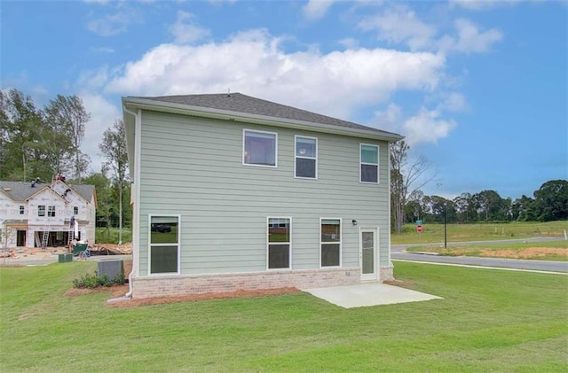 rear view of house with a patio area and a lawn