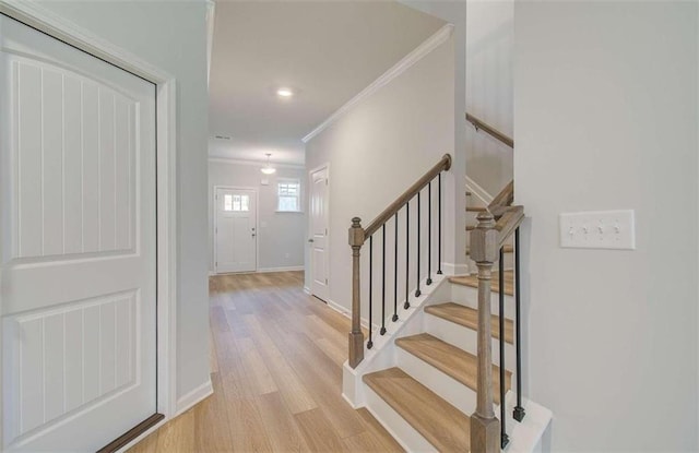 stairs featuring hardwood / wood-style floors and ornamental molding