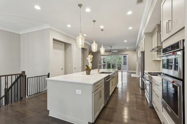 kitchen featuring light countertops, crown molding, a center island with sink, a sink, and appliances with stainless steel finishes
