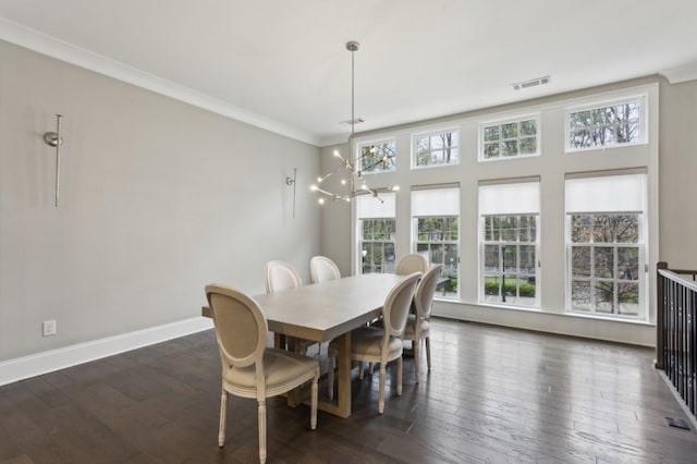 dining room with dark wood-type flooring, a healthy amount of sunlight, and a chandelier