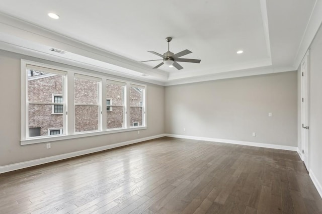 unfurnished room with baseboards, dark wood-style floors, a tray ceiling, and a ceiling fan