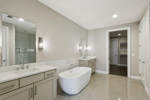 bathroom featuring a spacious closet, a sink, a stall shower, visible vents, and two vanities