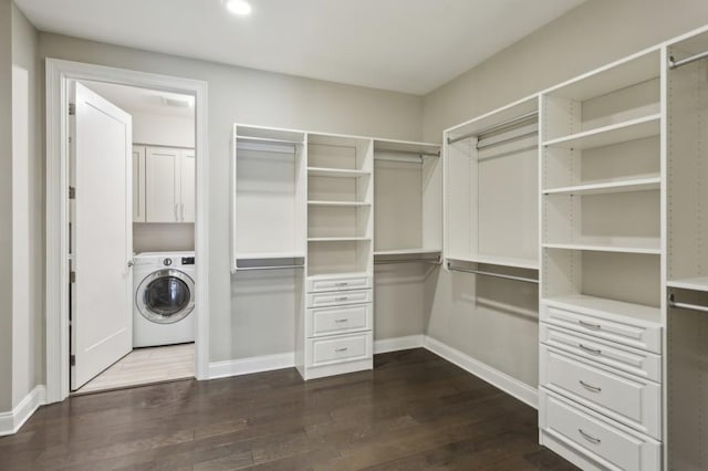 spacious closet with dark wood-type flooring and washer / dryer